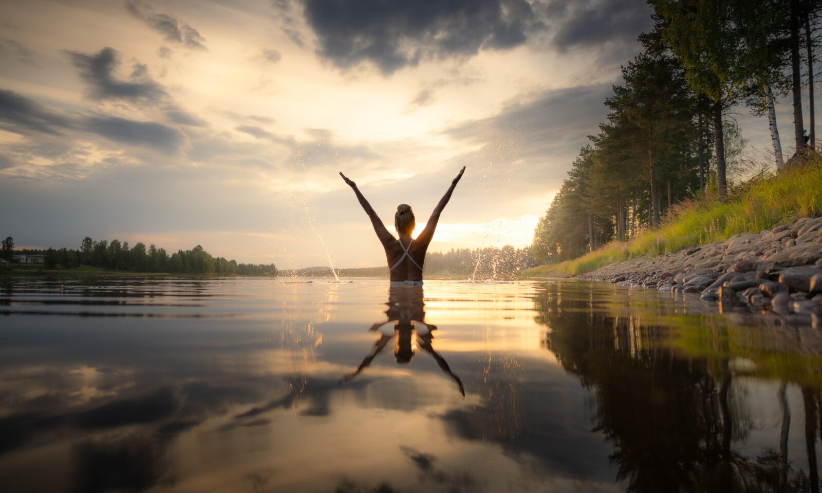 Woman swimming in the river at Aino Private Island Hotel, Lapland, Rovaniemi.