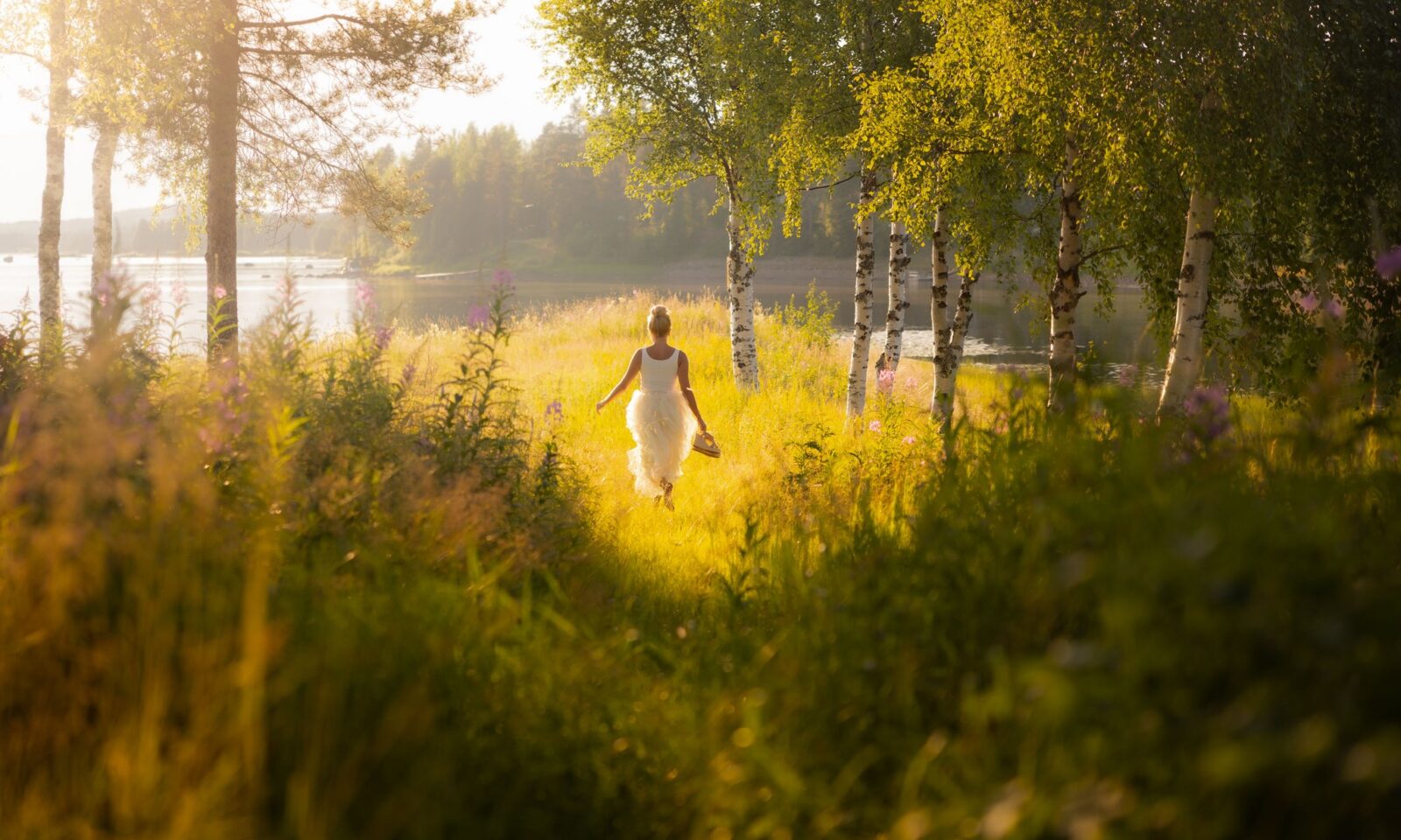 Woman walking in the Aino Private Island Hotel on a summer night. | Lapland, Rovaniemi