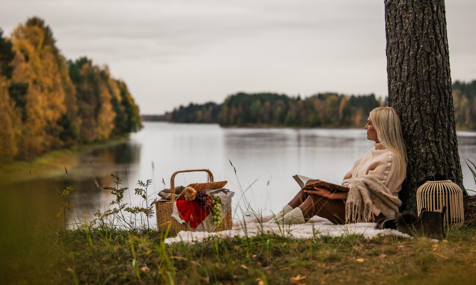Guest relaxing by the lake at Aino Private Island in autumn, Rovaniemi, Finnish Lapland.